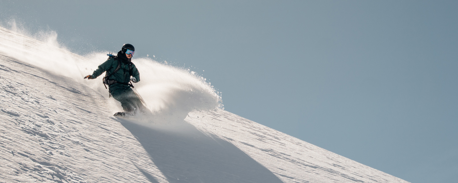 Guided snowboarding group exploring Hokkaido's untouched backcountry terrain